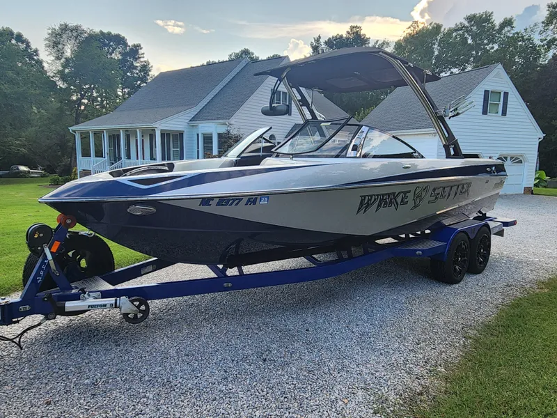 Slide: The Image of 2013 Malibu Wakesetter 23 LSV boat on trailer, parked in front of a house. - 3