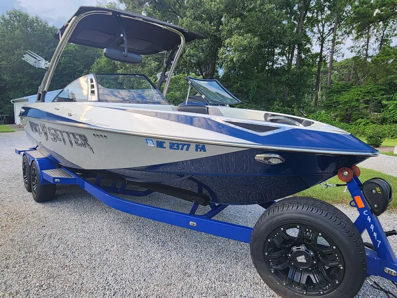 Slide: The Image of 2013 Malibu Wakesetter 23 LSV boat on trailer, parked on gravel driveway. - 4