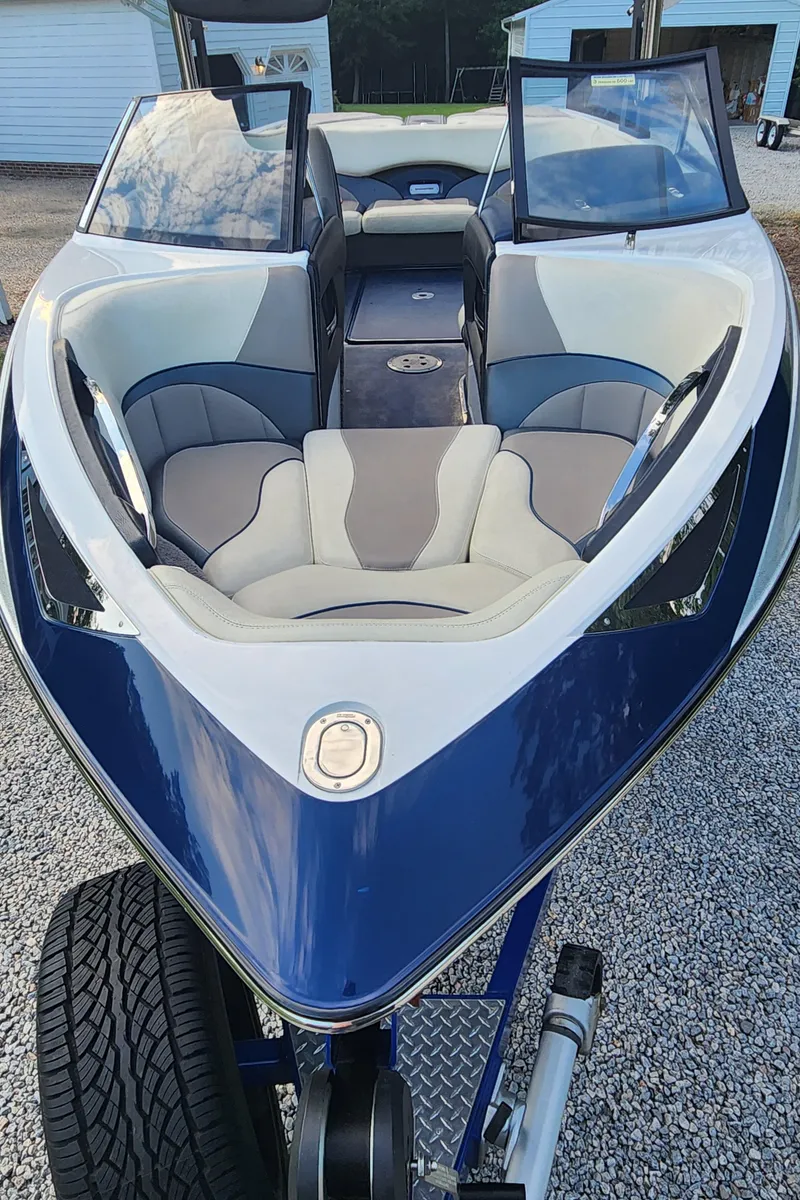 Slide: The Image of 2013 Malibu Wakesetter 23 LSV boat with sleek blue and white design on a trailer. - 6