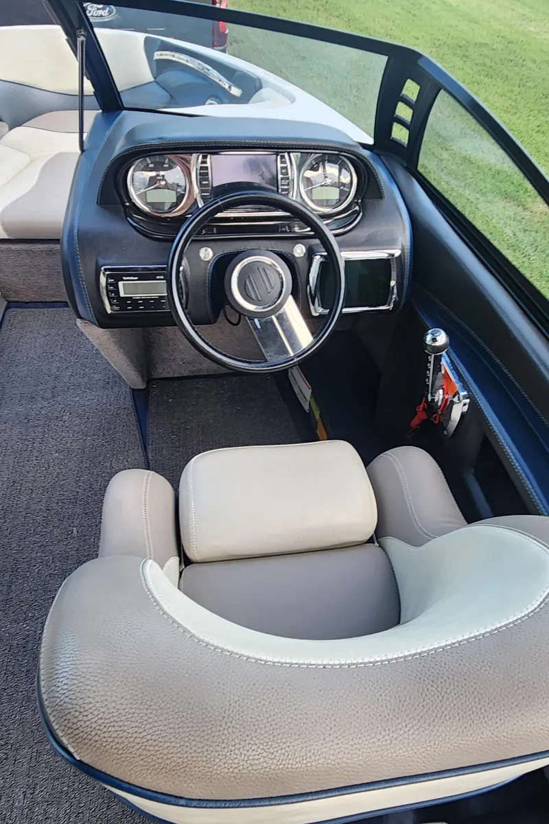 Slide: The Image of Interior of 2013 Malibu Wakesetter 23 LSV boat, featuring steering wheel and dashboard controls. - 9