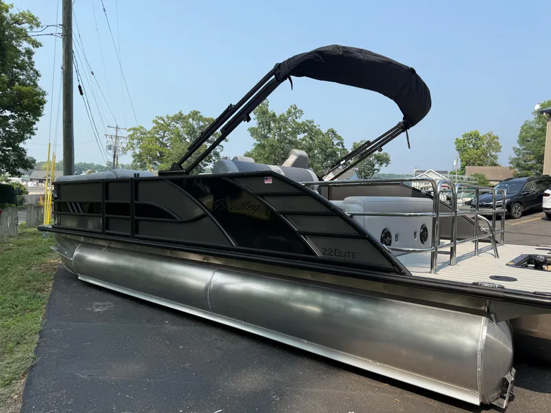 Slide: The Image of 2026 Bentley Pontoons Elite 223 Swingback Dual Capt. on display, sleek design, black canopy. - 6