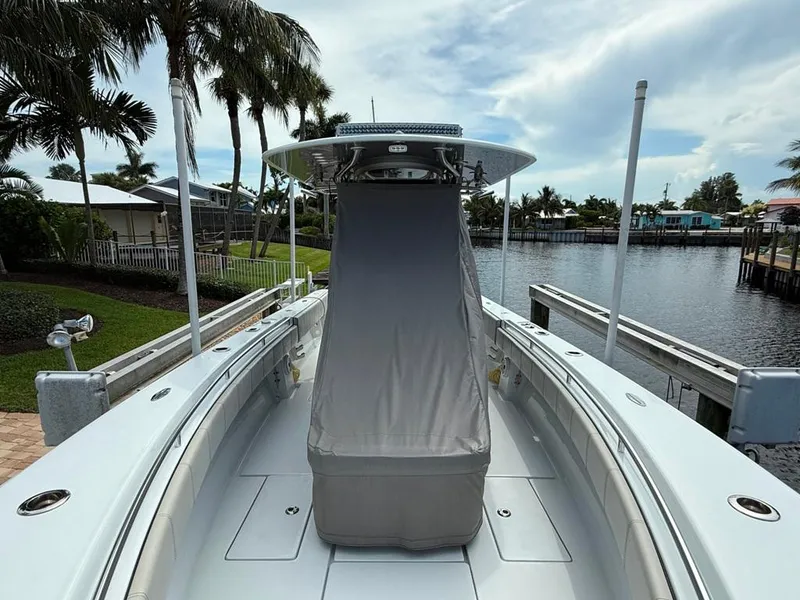 Slide: The Image of 2023 Contender 30 Tournament boat docked by a scenic waterfront with palm trees. - 12