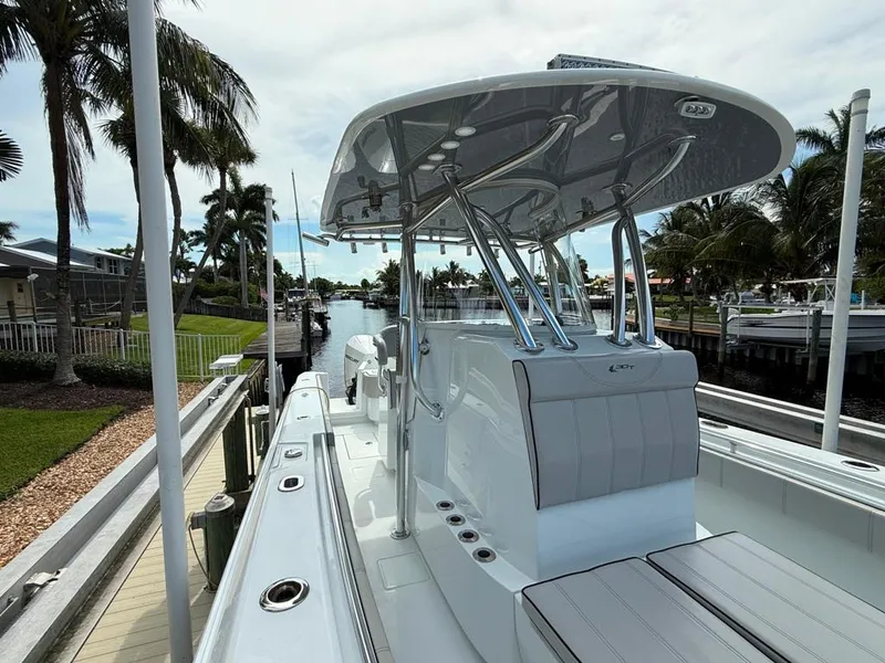 Slide: The Image of 2023 Contender 30 Tournament boat docked by palm trees and canal. - 18