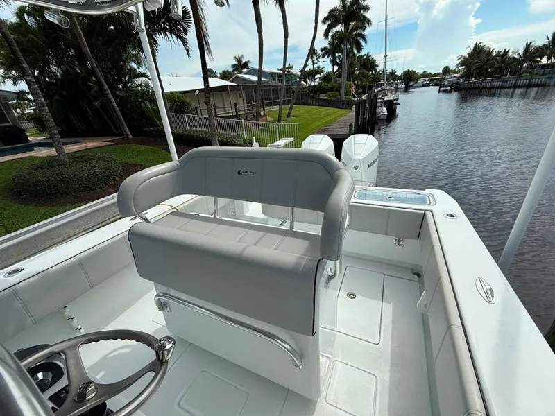 Slide: The Image of 2023 Contender 30 Tournament boat interior with helm and seating, docked by a canal. - 19