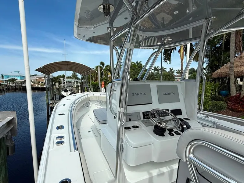 Slide: The Image of 2023 Contender 30 Tournament boat with Garmin navigation, docked by a scenic waterfront. - 22