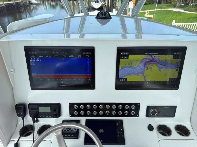 Slide: The Image of 2023 Contender 30 Tournament boat dashboard with dual Garmin displays and navigation controls. - 35