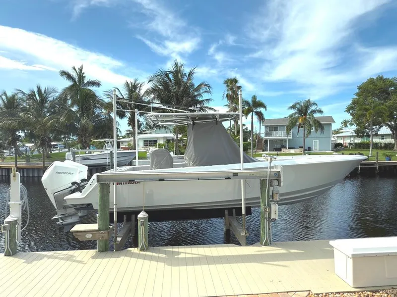 Slide: The Image of 2023 Contender 30 Tournament boat docked by palm trees and waterfront homes. - 4