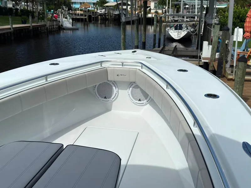 Slide: The Image of 2023 Contender 30 Tournament boat interior with cushioned seating and speakers, docked by the water. - 42