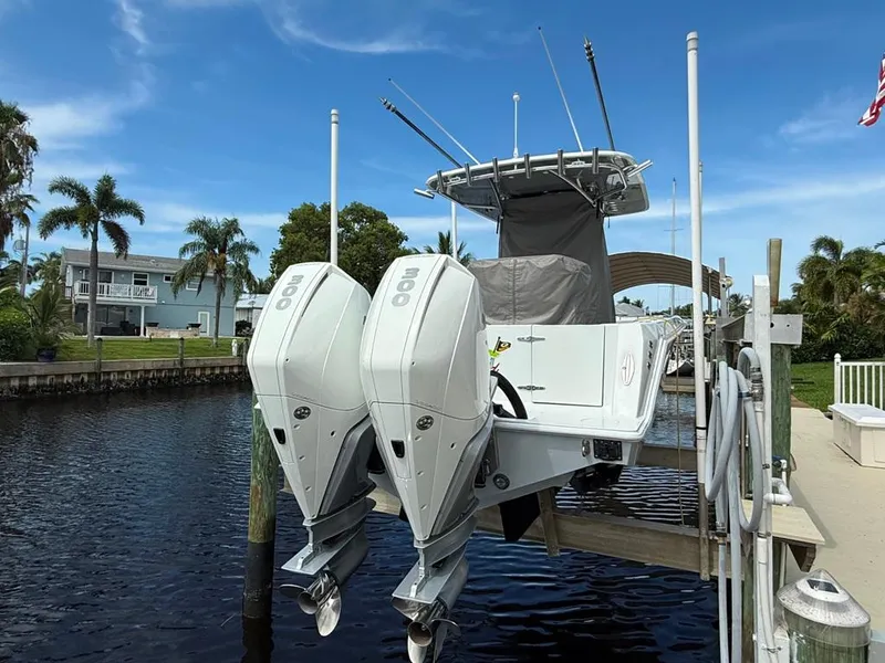 Slide: The Image of 2023 Contender 30 Tournament boat with dual engines docked by a canal under a clear sky. - 9