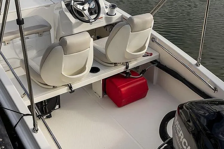 Slide: The Image of 2025 Boston Whaler 130 Super Sport interior with dual seats and Mercury engine. - 9