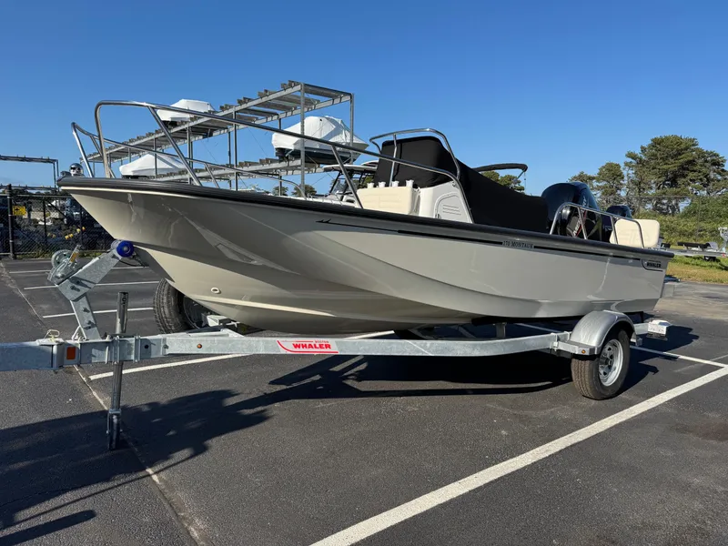 The Image of 2025 Boston Whaler 170 Montauk boat on trailer in parking lot, clear sky background. - 1