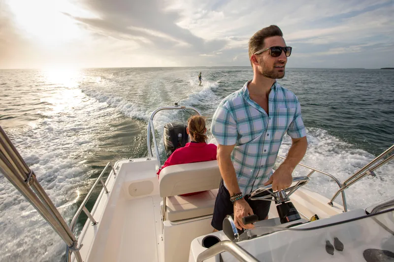 Slide: The Image of 2025 Boston Whaler 170 Montauk cruising with passengers, scenic ocean view, and sunset. - 10