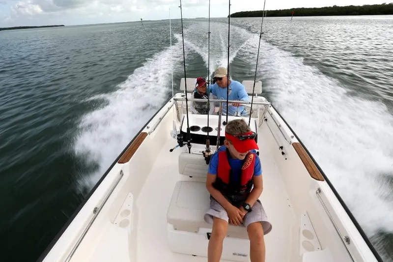 Slide: The Image of 2025 Boston Whaler 170 Montauk cruising with passengers on a scenic waterway. - 9