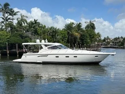 The Image of 2000 Tiara Yachts 5200 Express cruising on a serene waterway with lush greenery. - 0