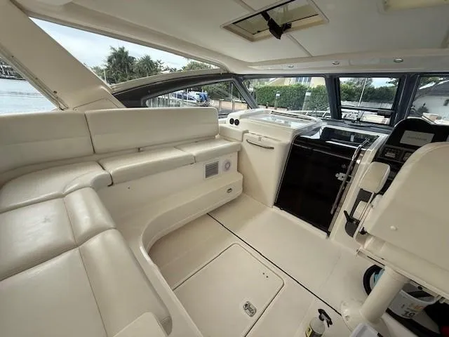 Slide: The Image of Interior of 2000 Tiara Yachts 5200 Express, featuring sleek white seating and modern controls. - 15