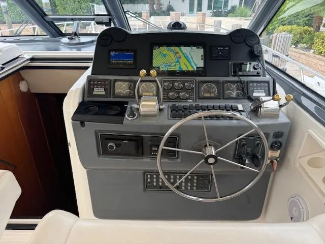 Slide: The Image of Helm of 2000 Tiara Yachts 5200 Express with navigation instruments and steering wheel. - 18