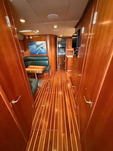 Slide: The Image of Interior of 2000 Tiara Yachts 5200 Express, featuring wood paneling and elegant seating area. - 26