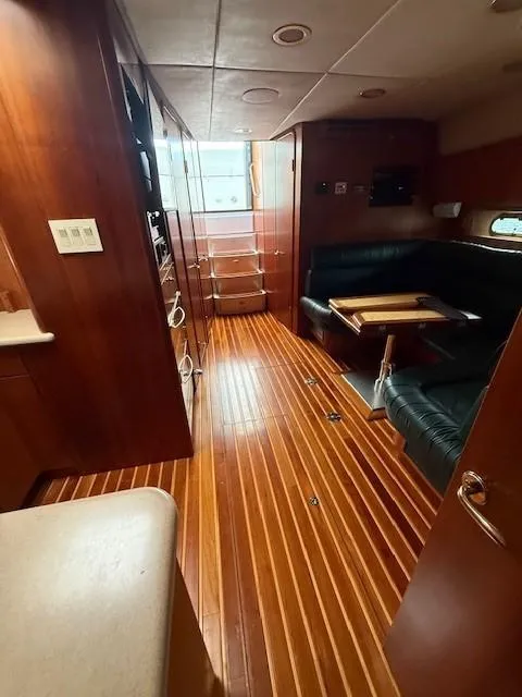 Slide: The Image of Interior of 2000 Tiara Yachts 5200 Express with wood flooring and leather seating. - 27