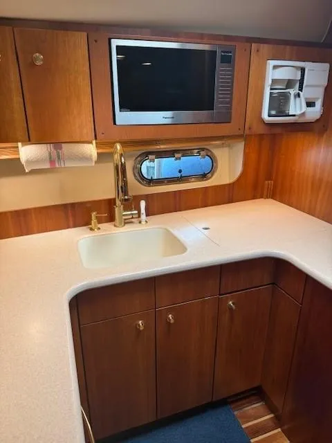 Slide: The Image of 2000 Tiara Yachts 5200 Express kitchen with sink, microwave, and coffee maker. - 36