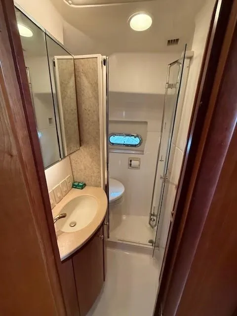 Slide: The Image of Bathroom interior of 2000 Tiara Yachts 5200 Express with sink, toilet, and shower. - 41