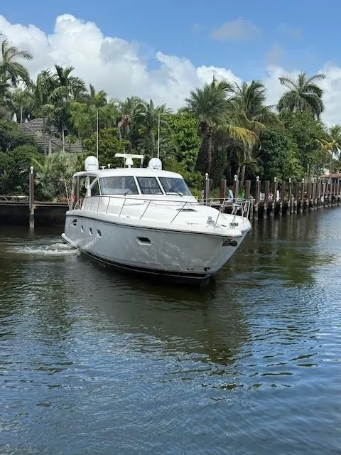 Slide: The Image of 2000 Tiara Yachts 5200 Express cruising on a tropical waterway with palm trees. - 5