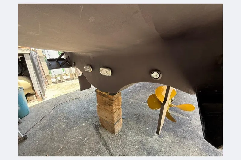 Slide: The Image of 2000 Tiara Yachts 5200 Express hull and propeller detail in a boatyard setting. - 59