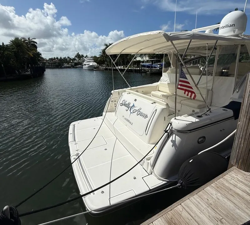 Slide: The Image of 2000 Tiara Yachts 5200 Express docked in a serene marina setting. - 9