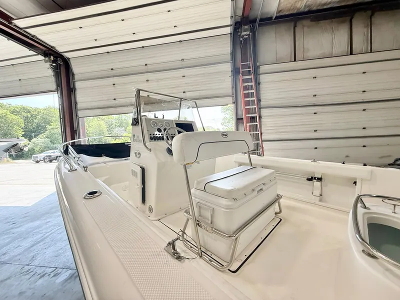 Slide: The Image of 2013 Key West 186CC boat in a garage, featuring a center console and seating. - 6
