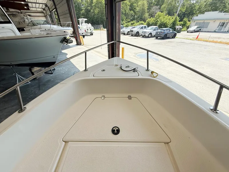Slide: The Image of 2013 Key West 186CC boat interior, docked in a garage with vehicles outside. - 8