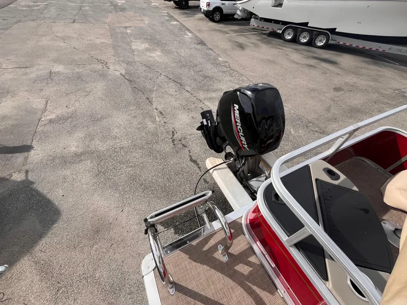 Slide: The Image of 2023 Sun Tracker Bass Buggy 18 DLX with Mercury outboard motor in a parking lot. - 15