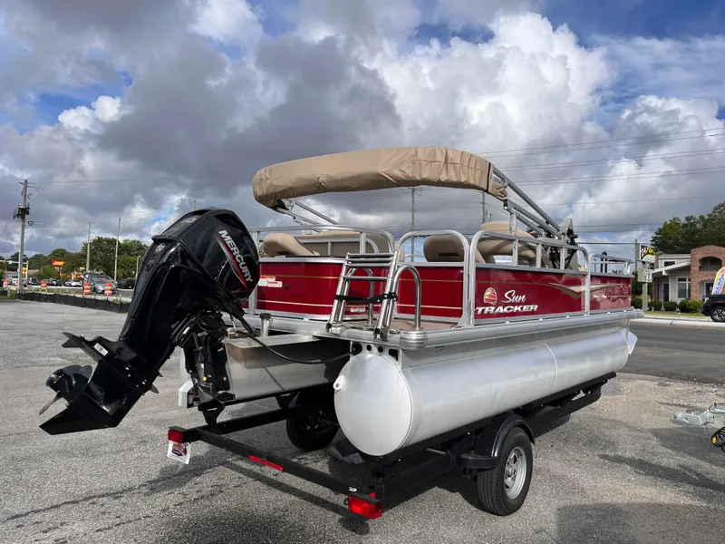 Slide: The Image of 2023 Sun Tracker Bass Buggy 18 DLX pontoon boat with Mercury outboard motor on trailer. - 5