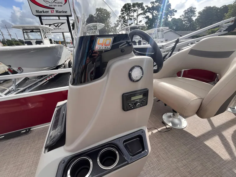 Slide: The Image of 2023 Sun Tracker Bass Buggy 18 DLX boat console with steering wheel and controls. - 9