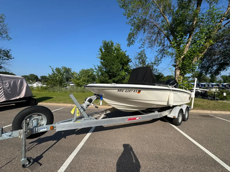 Slide: The Image of 2011 Boston Whaler 180 Dauntless boat on trailer in parking lot, sunny day. - 1