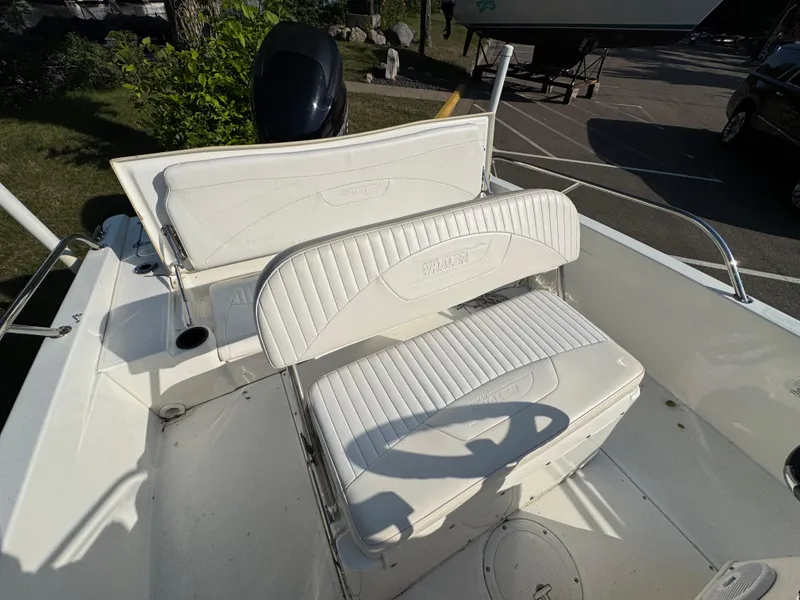 Slide: The Image of 2011 Boston Whaler 180 Dauntless boat interior with white cushioned seating and storage. - 16