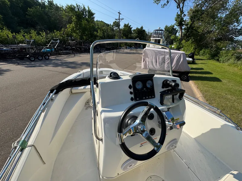 Slide: The Image of 2011 Boston Whaler 180 Dauntless boat cockpit with steering wheel and control panel. - 8