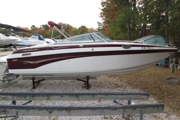 Slide: The Image of 2004 Crownline 288 BR boat on trailer, parked outdoors with trees in background. - 11