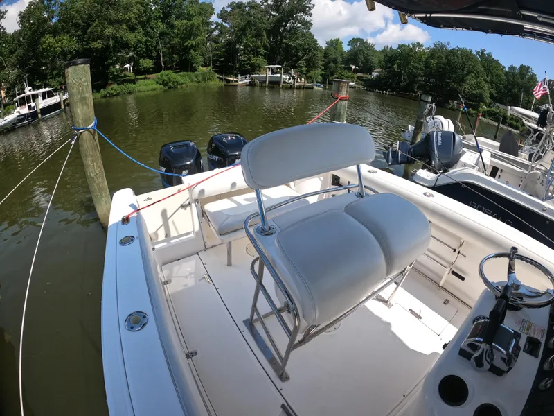 Slide: The Image of 2004 Boston Whaler 270 Outrage boat docked on a serene river. - 10