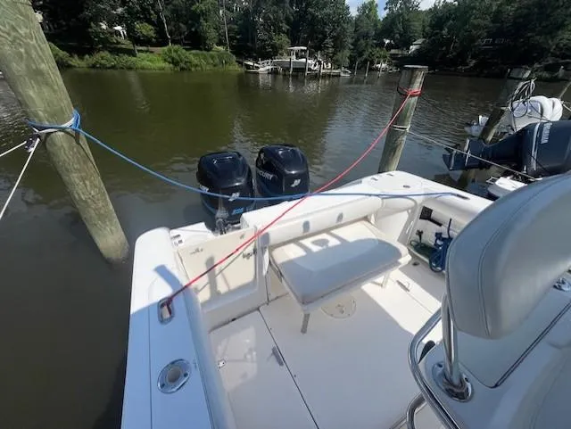 Slide: The Image of 2004 Boston Whaler 270 Outrage docked with dual Mercury engines, scenic river backdrop. - 18