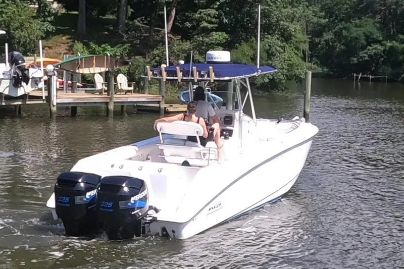 Slide: The Image of 2004 Boston Whaler 270 Outrage boat cruising on a calm river near a dock. - 5