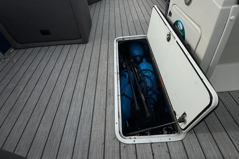 Slide: The Image of Storage compartment on 2020 Berkshire 23SB STS Entertainment boat, containing blue fenders and equipment. - 13