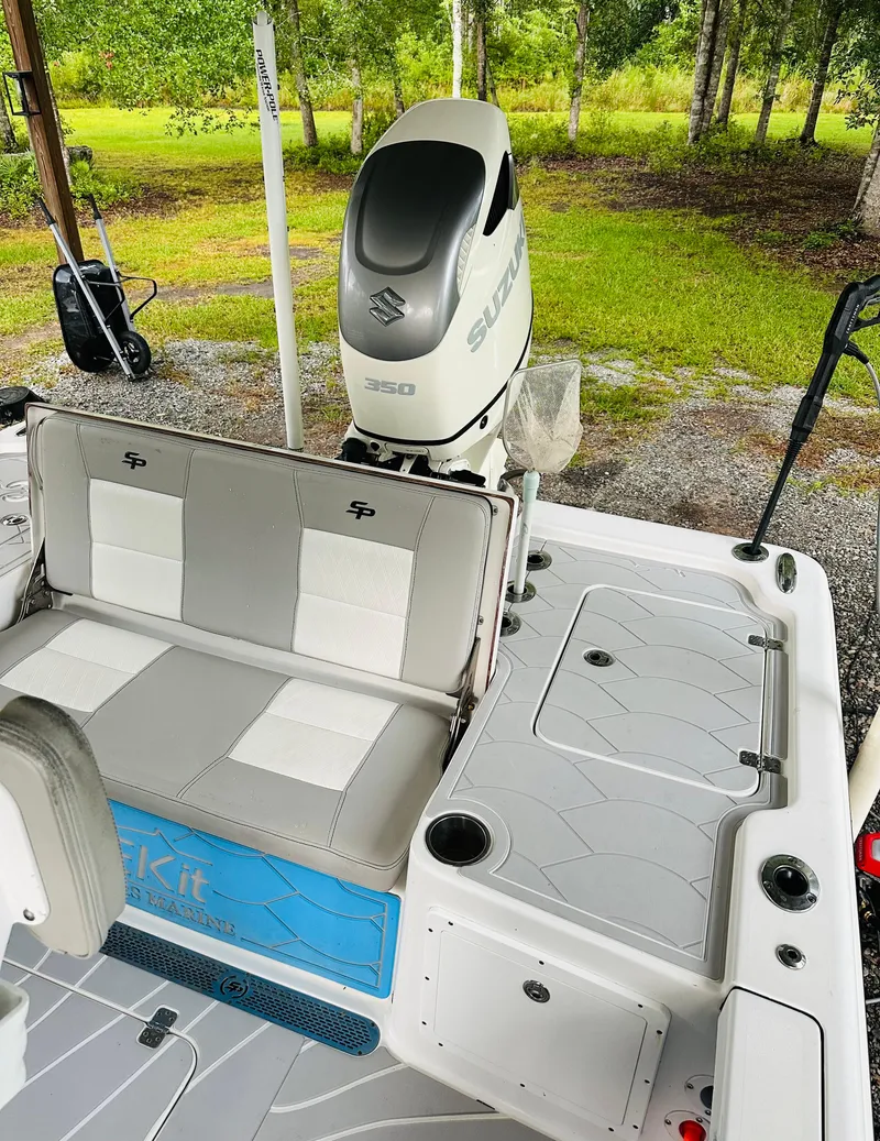Slide: The Image of 2019 Sea Pro 248 Bay boat interior with Suzuki 350 engine, featuring cushioned seating and storage. - 13
