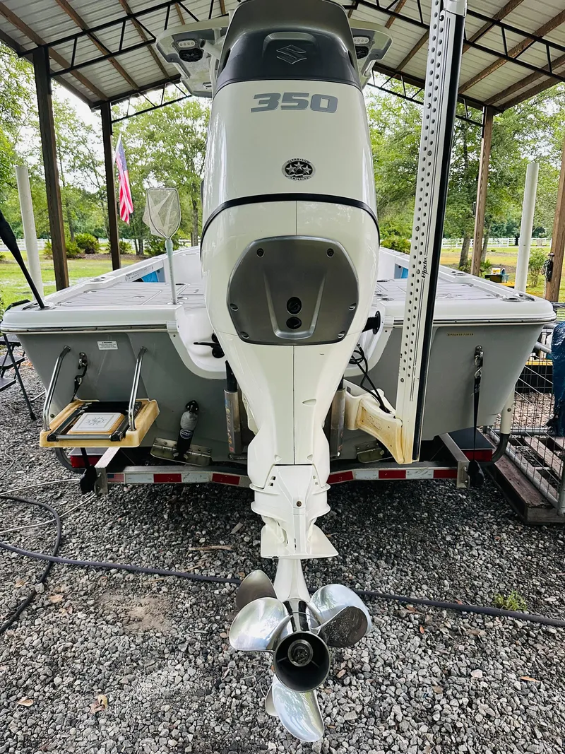 Slide: The Image of 2019 Sea Pro 248 Bay boat with powerful 350 engine, parked under a shelter. - 15
