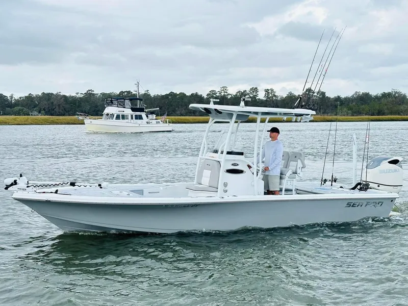 Slide: The Image of 2019 Sea Pro 248 Bay boat on water with fishing rods and Suzuki engine. - 3