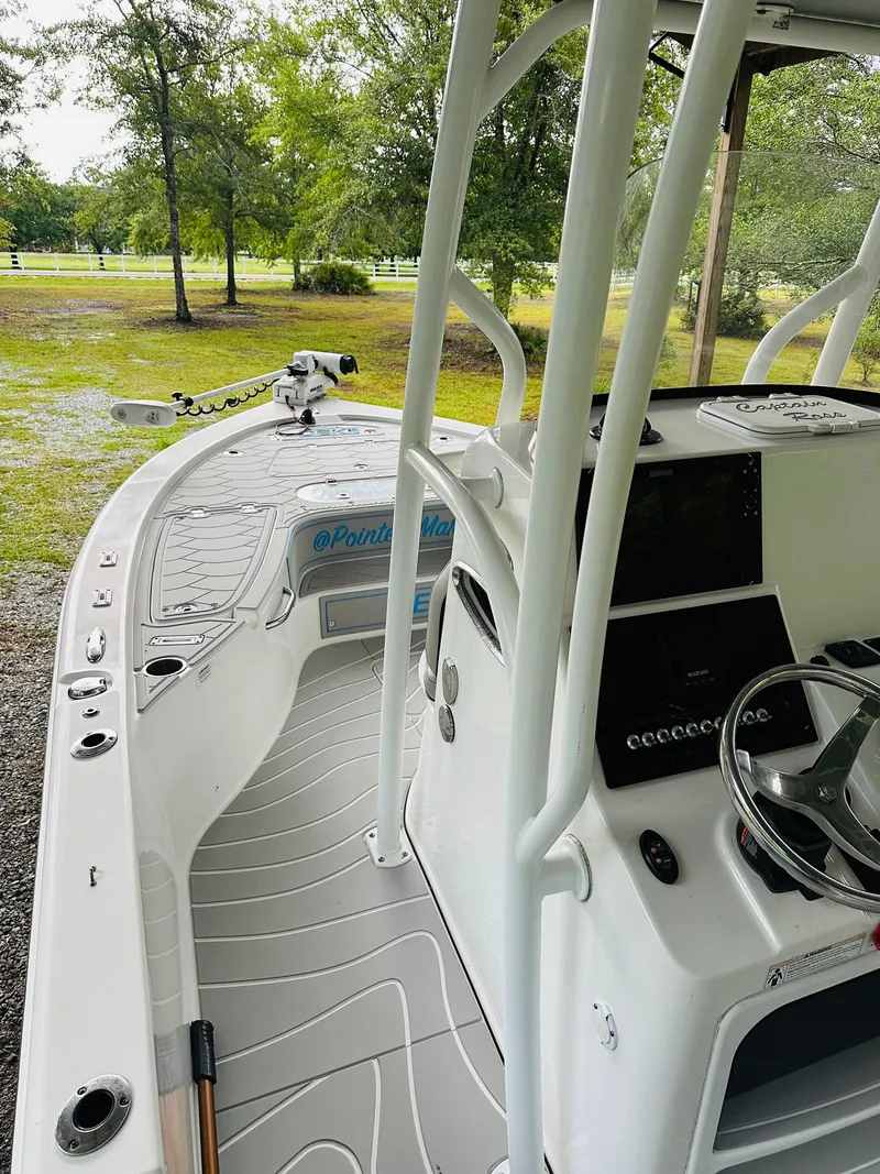 Slide: The Image of 2019 Sea Pro 248 Bay boat interior with steering console and fishing equipment. - 5