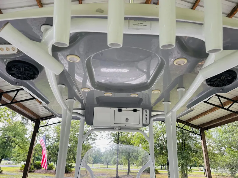 Slide: The Image of 2019 Sea Pro 248 Bay boat interior with rod holders and speakers under a canopy. - 8
