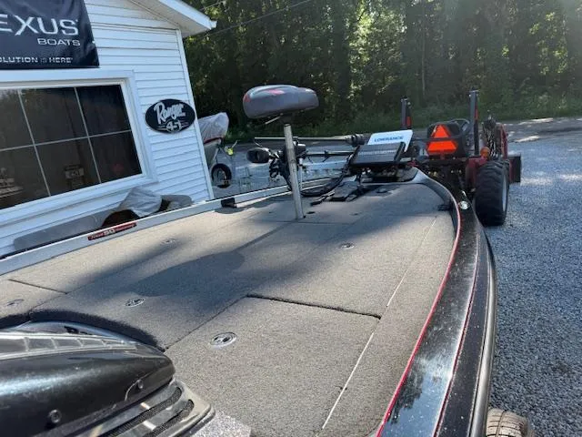 Slide: The Image of 2019 Ranger Z521C boat on trailer, parked near a building with trees in background. - 6
