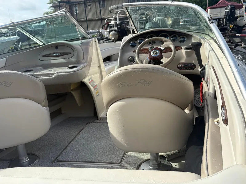 Slide: The Image of 2003 Sea Ray 200 Bow Rider interior with beige seating and steering wheel. - 5