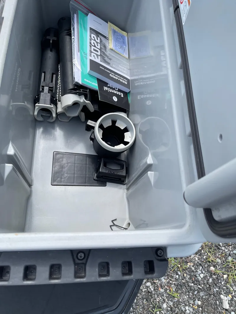 Slide: The Image of Open storage compartment of 2022 Sea-Doo Fishpro Sport 170 with manuals and accessories. - 14