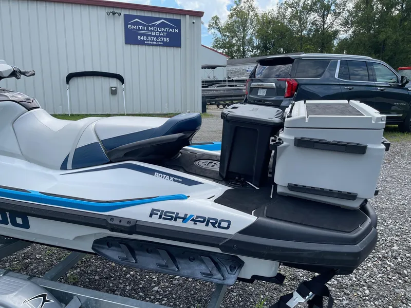Slide: The Image of 2022 Sea-Doo Fishpro Sport 170 jet ski with storage boxes, parked outside a boat dealership. - 19