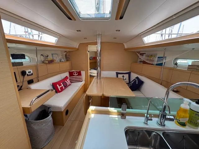 Slide: The Image of Interior of 2018 Jeanneau Sun Odyssey 389 sailboat with modern seating and kitchen area. - 11